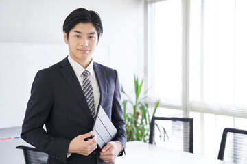会議室でタブレットを持つ日本人男性ビジネスマン
