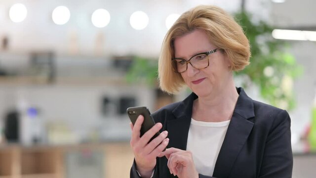 Portrait of Old Businesswoman using Smartphone 