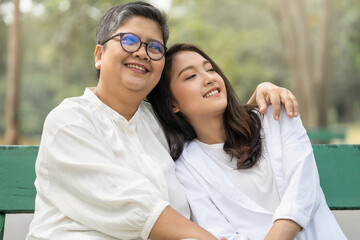 Fototapeta premium Happy Mother's Day Mother and daughter show their love by embracing each other on the holidays in the park.