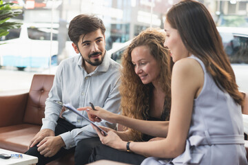 Rent a car business concept. Agent rental vehicles company giving a car key to client / customer in office after explain agreement document and term of used to lender.