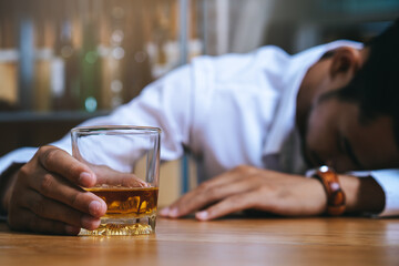 Drunk person sleep at bar have a alcohol drink in hands