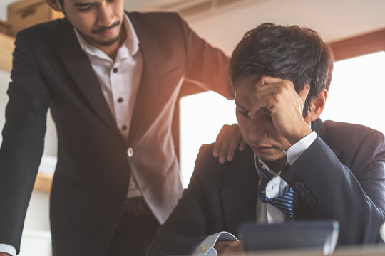 Colleague touch shoulder encouraging young businessman after work failure.