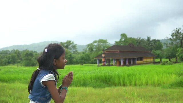 little girl praying  near temple  farm malvan maharashtra