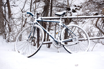 Snow covered bicycle locked to a fence by North Mississippi River Boulevard. St Paul Minnesota MN USA