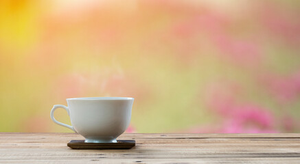 Naklejka na ściany i meble coffee cup on wooden table with flower background