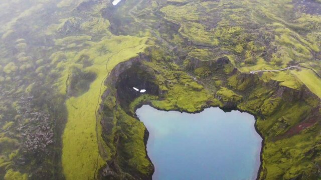 Picturesque View Of Tjarnargigur, Pond Crater With Reflections By The Lush Green Moss In Lakagigar, Iceland. - aerial drone shot - backwards