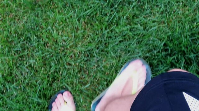 Person walking on grass with flip flops