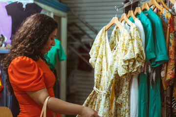 Joven mujer mexicana compra revisa ropa en tienda boutique