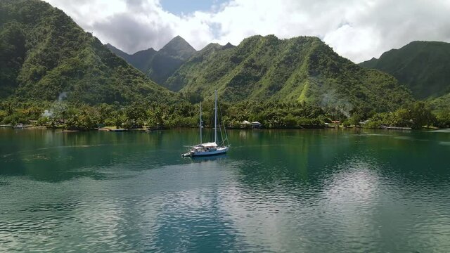 Sailboat in lagoon, beautiful coastal landscape of Tahiti. Drone aerial shot. Tropical paradise, island travel. Teahupoo, French Polynesia 4k.