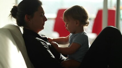 Candid mother and baby infant interaction. Real life authentic mom and child. Toddler putting hand parent mouth