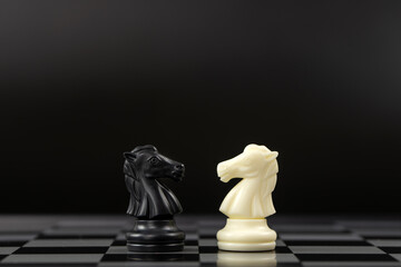 Black and white knight chess pieces on the board for business competition concept