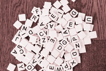 Game tiles with letters dumped onto a table; mixed tiles with the alphabet spilled onto the floor