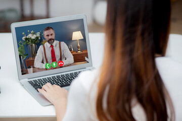 Young asian businesswoman video conference and discussion with businessman, woman work from home with laptop computer with social distancing, meeting online, communication and business concept.
