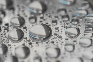 Macro photography of water drops on a mirror reflective surface