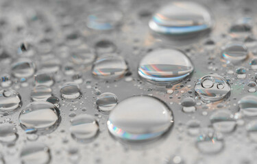 Macro photography of water drops on a mirror reflective surface. Concept of being different than the rest