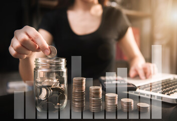 businesswoman hand puting coins in glass for saving money. concept finance and accounting in the home.