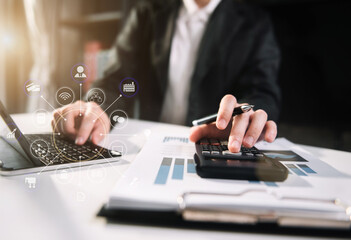 Female businessman working with holding a pen and using a calculator to calculate the numbers of...