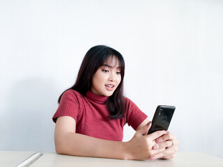 Feeling happy and smile face of Young beautiful asian woman looking on the smartphone. Indonesia women