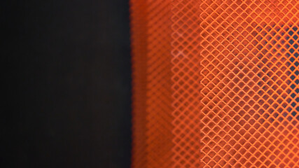 Red fiberglass mesh on a dark background.