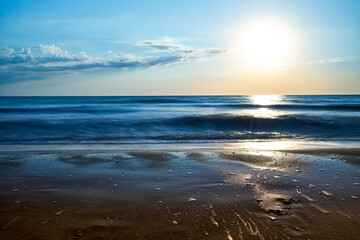 Fototapeta na wymiar Sea sunset. Quiet calm sea. Sand beach.