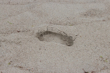 A footprint left by a man in the sand