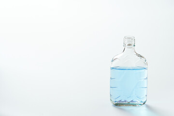 Naklejka premium 青い色水を入れた透明な空き瓶