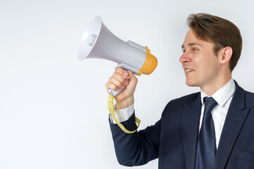 A businessman speaks into a loudspeaker. White background.