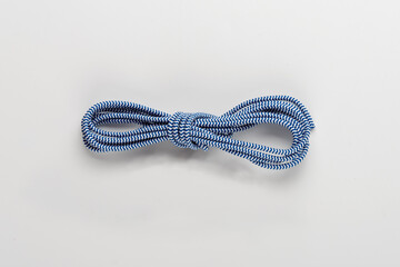 Striped white-blue lace in a skein on a white background. Close-up.