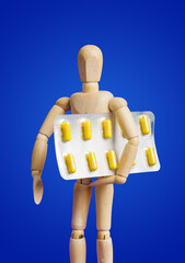Wooden toy figure with pills on blue
