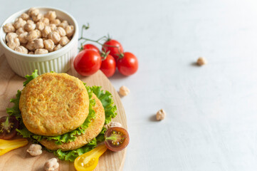 Fresh vegan cutlets, tomatoes, lettuce and bowl with chickpeas on a wooden board. Home made with vegetables and chickpeas.The concept of healthy and vegetarian food.  Plant based food concept