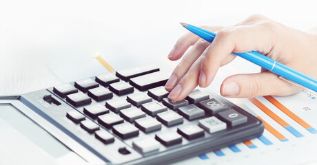 Finance and business. Female small business. Hand pointing at statistics chart. calculator on financial graphs on desk. Accounting budgeting loans or market analysis. finance office web banner