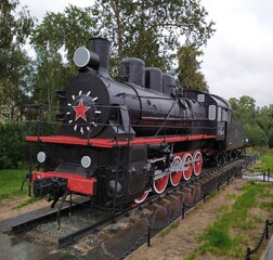 Vintage military black steam locomotive on rails