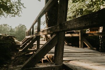 Old wooden bridge in the forest at sunset