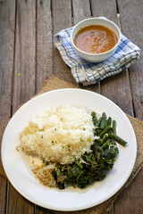 Nasi Pecel. Traditional Javanese rice dish of steamed rice with vegetable salad, peanut dressing, tempeh, beancurd and crackers.