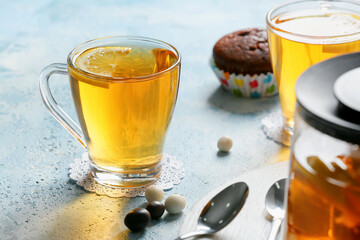 Cups of hot tea and sweets on table