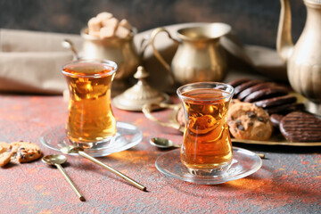 Cups of hot Turkish tea and sweets on table