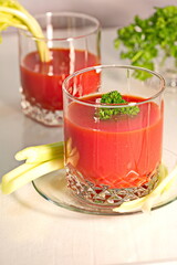 Freshly prepared tomato juice with celery leaves in a glass Cup is on the table. The concept of healthy food. It is an element of vegetarianism, keto diet, paleo diet