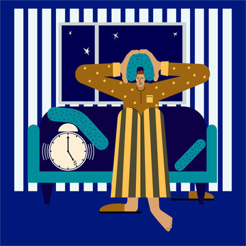 A tired man sits in bed early in the morning with an alarm clock in his hands.