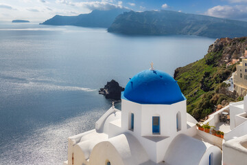 Greek orthodox church with blue domes and sea in  Santorini island, Greece.