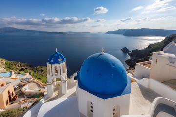 Beautiful view of Greek orthodox church with blue domes and sea in  Santorini island, Greece.