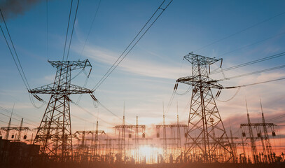 High-voltage power lines at sunset or sunrise. High voltage electric transmission tower