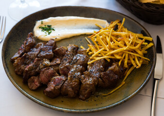 Tasty aged beef entrecote with French fries and sauce on plate