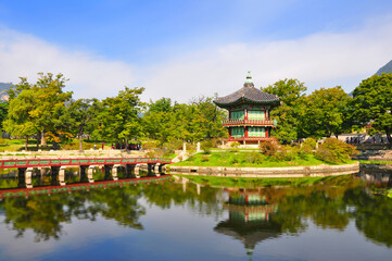 Fototapeta na wymiar Beautiful view of traditional Hyangwonjeong pavilion among lush green trees with amazing water reflection in the pond at late summer, Gyeongbokgung, Seoul, South Korea
