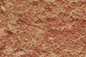 A fragment of a red-orange painted relief wall with a concrete texture.