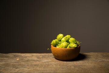 Beer. Still life with Vintage beer barrel and glass light beer. Fresh amber beer concept. Green hop and gold barley on wooden table. Ingredients for brewery. Brewing traditions
