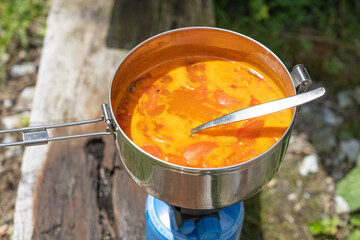 Tomatensuppe wird auf Gaskocher zubereitet, Schweiz