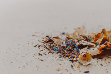 background for art workshop: shavings from sharpening colored pencils lying on a craft paper background with space for your text or advertising