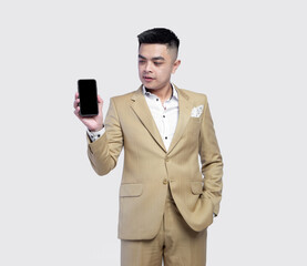 Naklejka premium Young handsome business man wearing suit holding mobile phone isolated on background