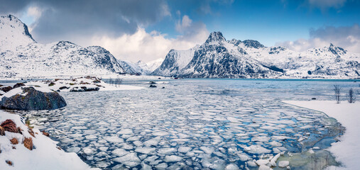 Incredible winter scene over polar circle. Frozen Boosen fjord on Flakstadoya island. Panoramic...