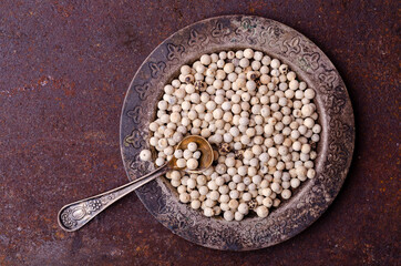 White peppercorn in a metal dish